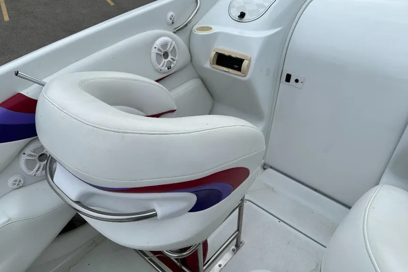 Slide: The Image of Interior of a 1999 Baja 29 Outlaw boat with white seating and colorful accents. - 7