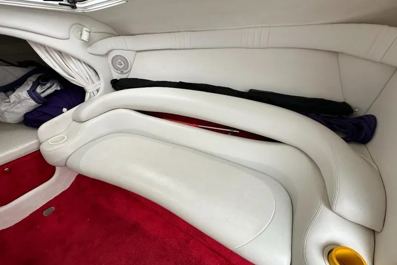 Slide: The Image of Interior of a 1999 Baja 29 Outlaw boat with white seating and red carpet. - 16