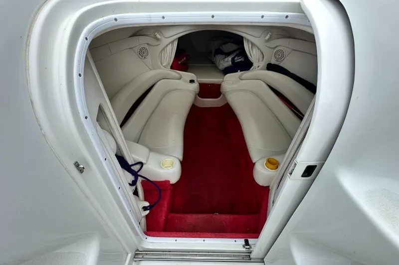 Slide: The Image of Interior of a 1999 Baja 29 Outlaw boat with white seating and red carpet. - 14