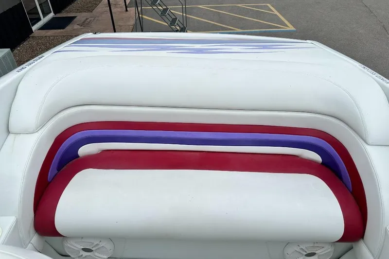 Slide: The Image of 1999 Baja 29 Outlaw boat interior with white, red, and purple seating. - 11