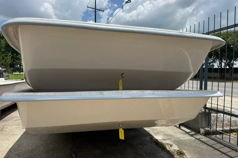 Slide: The Image of 2027 Carolina Skiff 2790 boat hulls stacked outdoors under cloudy sky. - 6