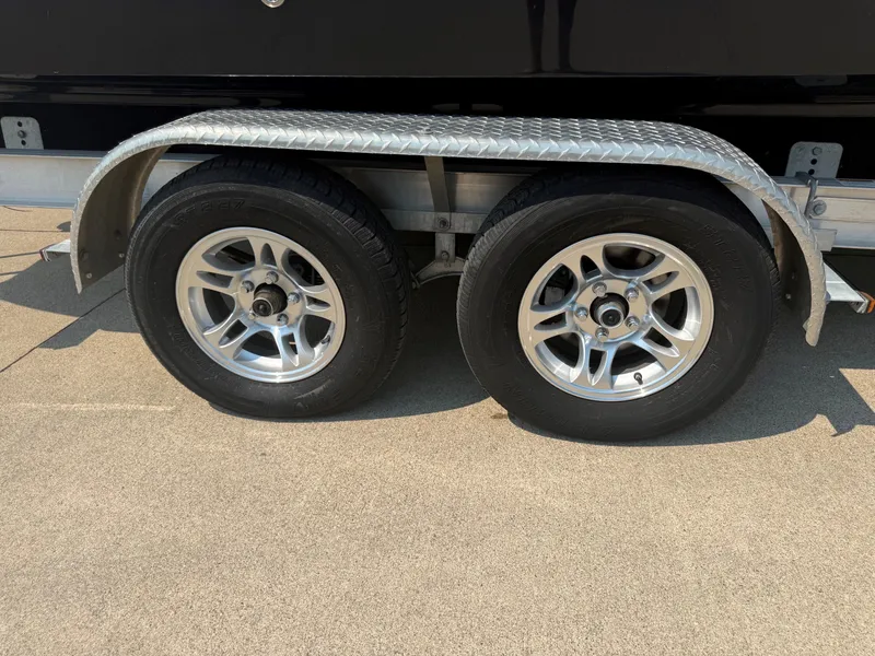 Slide: The Image of A tandem axle trailer with silver rims and black tires on a concrete surface. - 35