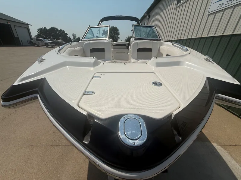 Slide: The Image of A 2011 Chaparral 244 Sunesta with an open bow area, parked on a concrete lot. - 4