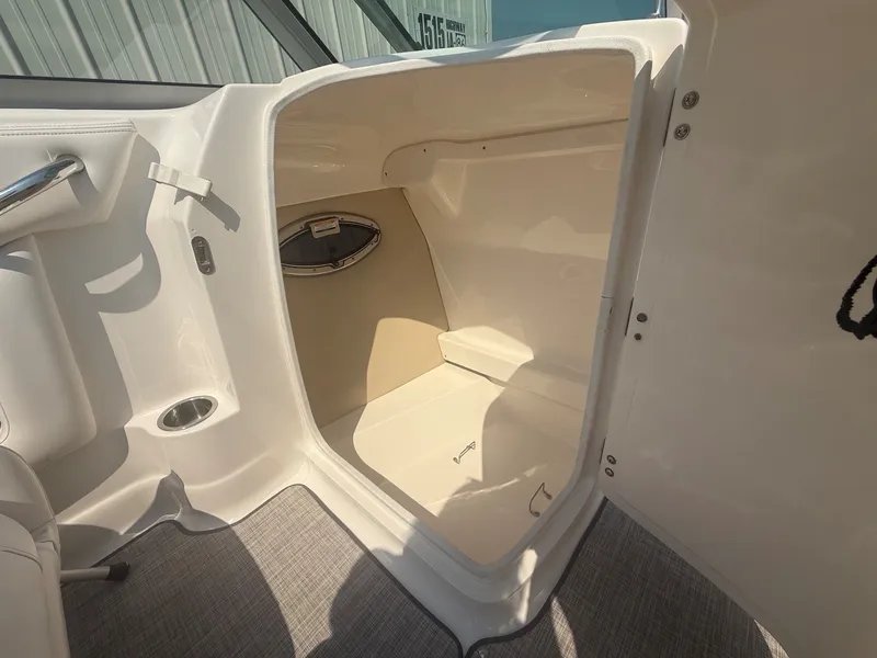 Slide: The Image of The image shows the interior of a 2011 Chaparral 244 Sunesta boat with an open storage compartment. - 20