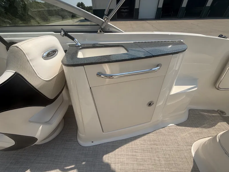 Slide: The Image of The 2011 Chaparral 244 Sunesta features a compact onboard kitchenette with a sink and storage. - 28