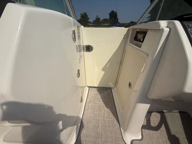 Slide: The Image of The cabin door of a 2011 Chaparral 244 Sunesta with light flooring and a control panel. - 24