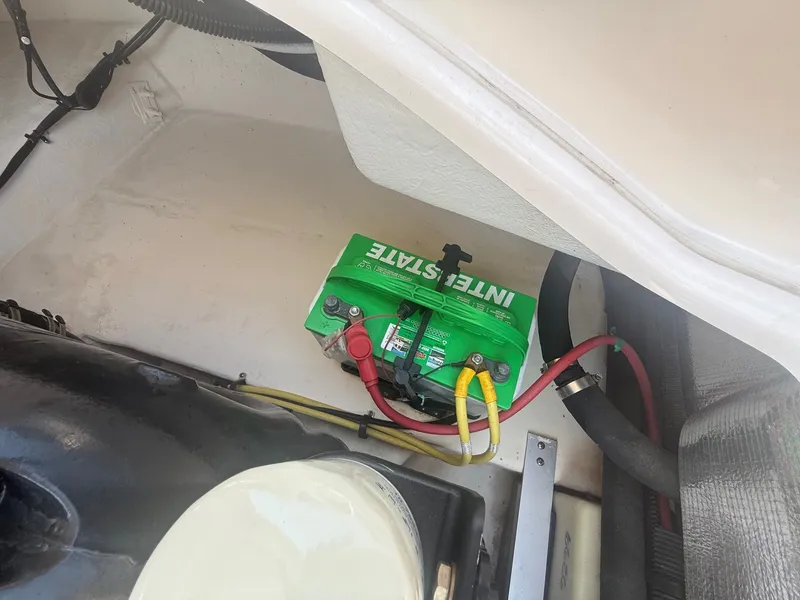 Slide: The Image of A green boat battery is visible in a compartment of the 2011 Chaparral 244 Sunesta. - 31