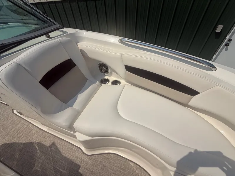 Slide: The Image of The image shows the cockpit of a 2011 Chaparral 244 Sunesta with white upholstery and cup holders. - 16