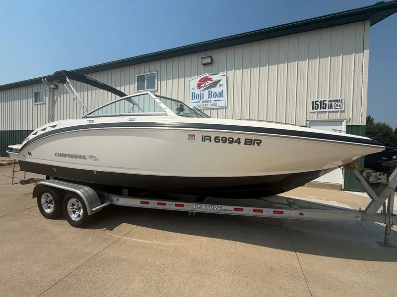 Slide: The Image of A white 2011 Chaparral 244 Sunesta boat on a trailer in front of a building. - 1