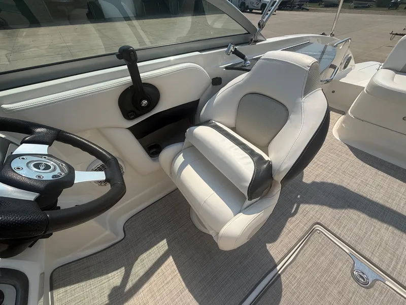 Slide: The Image of The image shows the helm of a 2011 Chaparral 244 Sunesta with a white captain's chair. - 17