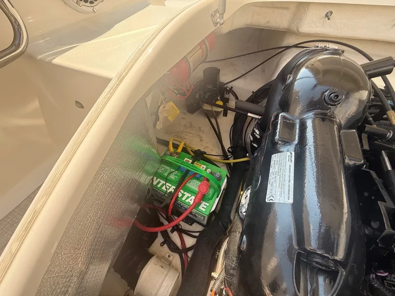 Slide: The Image of A view inside the engine compartment of a 2011 Chaparral 244 Sunesta, showing the battery and engine. - 32