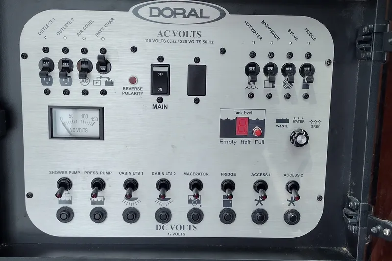 Slide: The Image of Control panel of a 2006 Doral Monticello 250 boat, featuring AC and DC volt switches. - 25