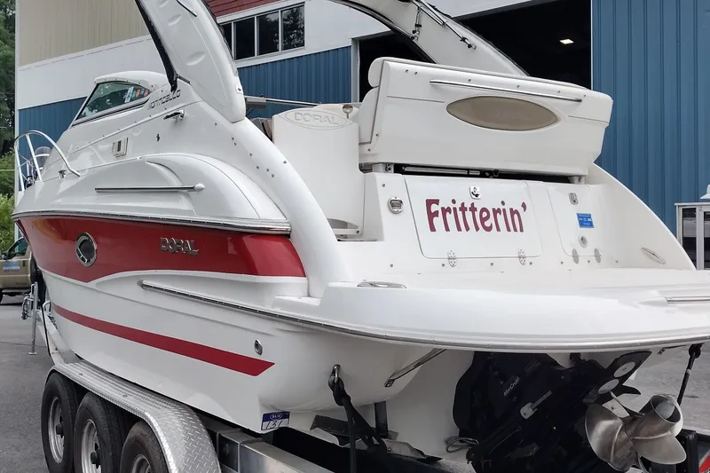 Slide: The Image of 2006 Doral Monticello 250 boat with "Fritterin'" name, on trailer, in front of blue building. - 8