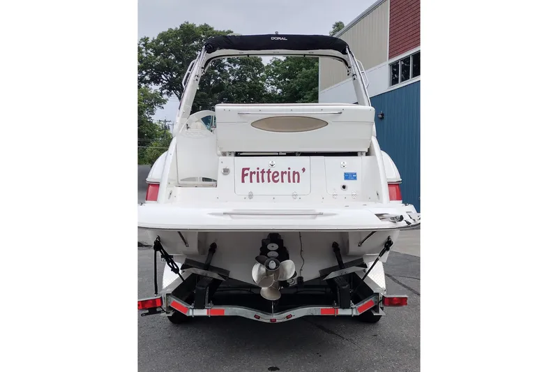 Slide: The Image of 2006 Doral Monticello 250 boat, rear view, parked on trailer, with "Fritterin'" name displayed. - 7