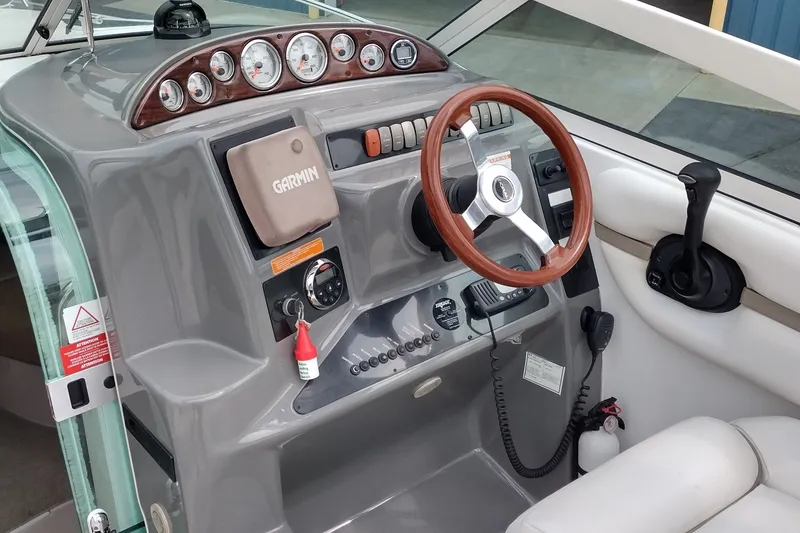 Slide: The Image of 2006 Doral Monticello 250 boat dashboard with Garmin GPS and wooden steering wheel. - 15