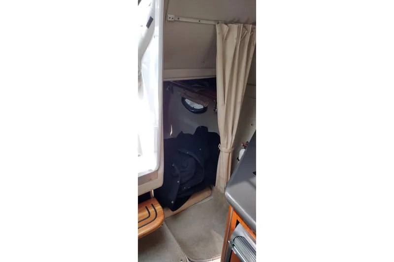 Slide: The Image of Interior cabin view of a 2006 Doral Monticello 250 boat, featuring a cozy sleeping area. - 33