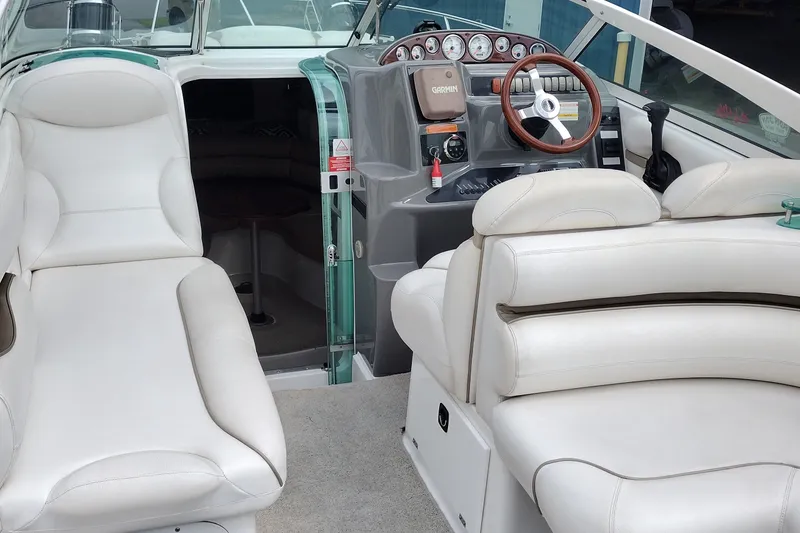 Slide: The Image of 2006 Doral Monticello 250 boat interior with white seating and modern dashboard. - 12