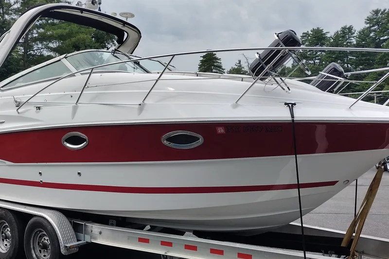 Slide: The Image of 2006 Doral Monticello 250 boat on trailer, featuring sleek red and white design. - 4