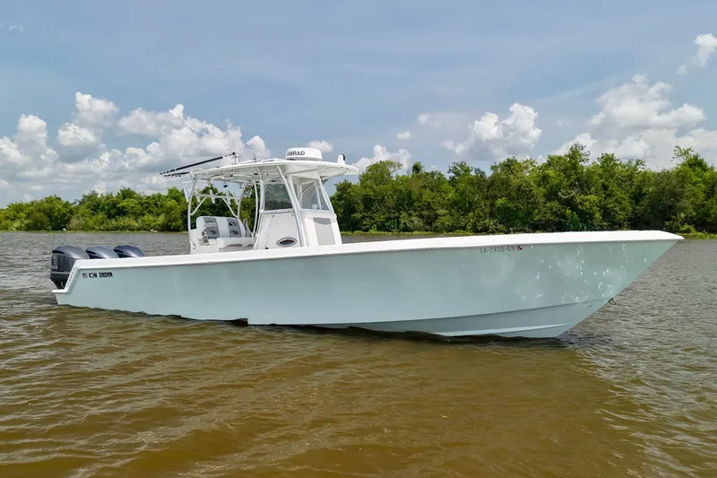 Slide: The Image of 2016 Contender 35 ST boat on water, clear sky, lush green background. - 2