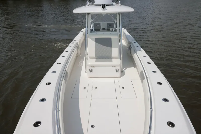 Slide: The Image of 2016 Contender 35 ST boat on calm water, showcasing spacious deck and seating area. - 24