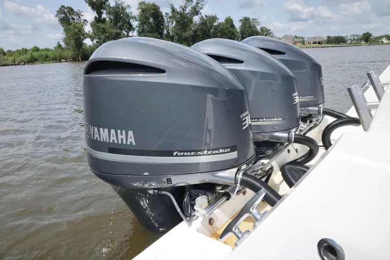 Slide: The Image of Triple Yamaha outboard engines on a 2016 Contender 35 ST boat in a scenic waterway. - 21