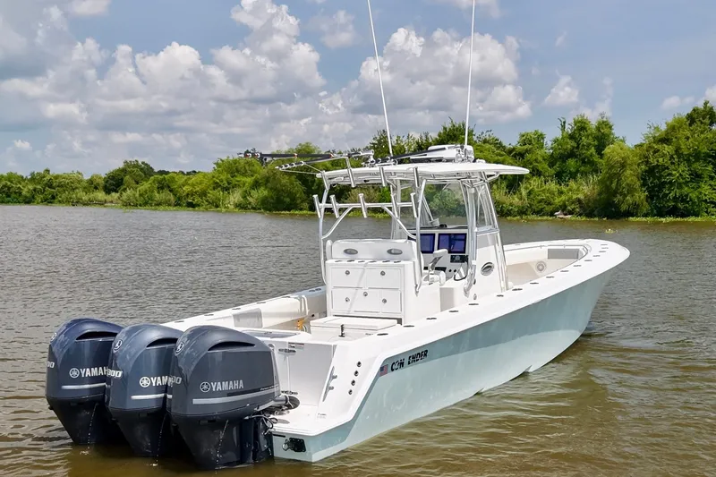 Slide: The Image of 2016 Contender 35 ST boat with triple Yamaha engines on a calm river. - 5