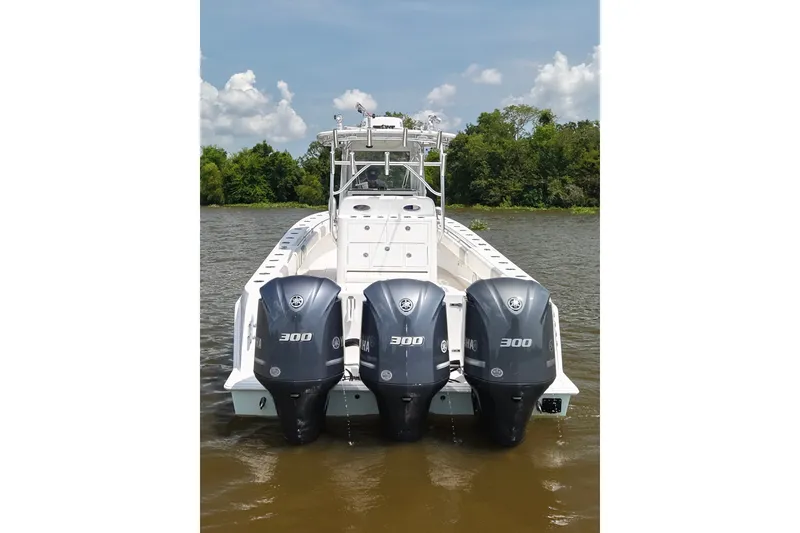 Slide: The Image of 2016 Contender 35 ST boat with triple Yamaha 300 engines on a calm river. - 6