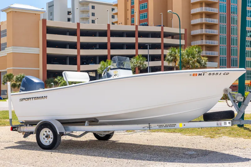 The Image of 2015 Sportsman Island Reef 17 Center Console boat on trailer, urban background. - 0