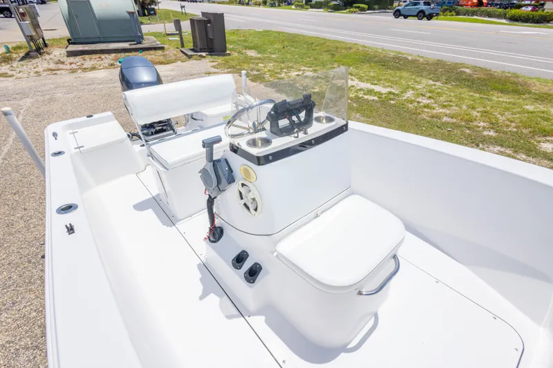 Slide: The Image of 2015 Sportsman Island Reef 17 Center Console boat, white interior, parked near a road. - 27