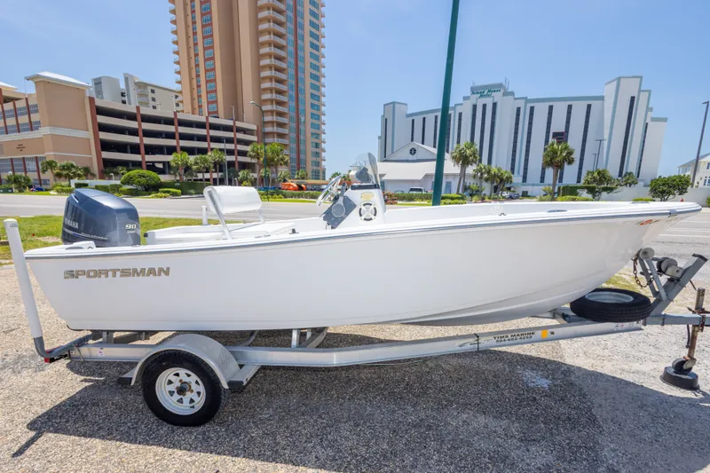 Slide: The Image of 2015 Sportsman Island Reef 17 Center Console boat on trailer, urban backdrop. - 9
