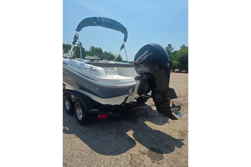 Slide: The Image of 2021 Tahoe 550 TF boat with Mercury outboard motor on a trailer in a parking lot. - 2
