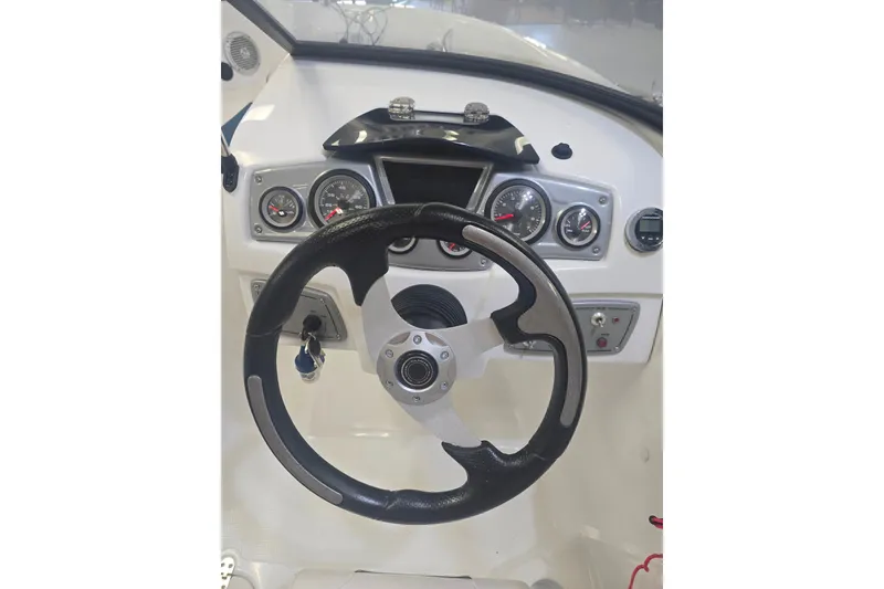 Slide: The Image of Steering wheel and dashboard of 2021 Tahoe 550 TF boat, featuring gauges and controls. - 6