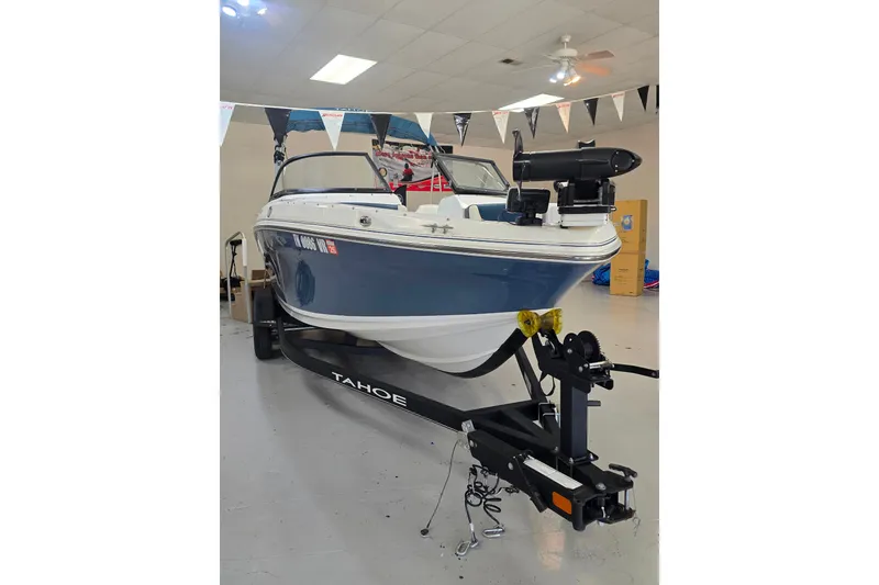 Slide: The Image of 2021 Tahoe 550 TF boat on trailer in showroom, blue and white design. - 13