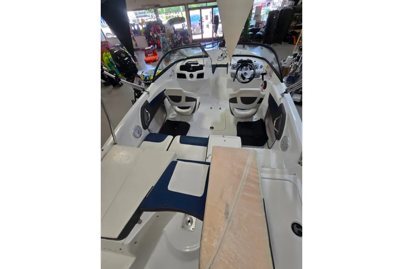 Slide: The Image of 2021 Tahoe 550 TF boat interior with seating and steering wheel in showroom. - 12
