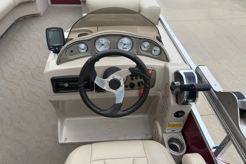 Slide: The Image of 2011 Harris Cruiser 220 boat dashboard with steering wheel and gauges. - 8