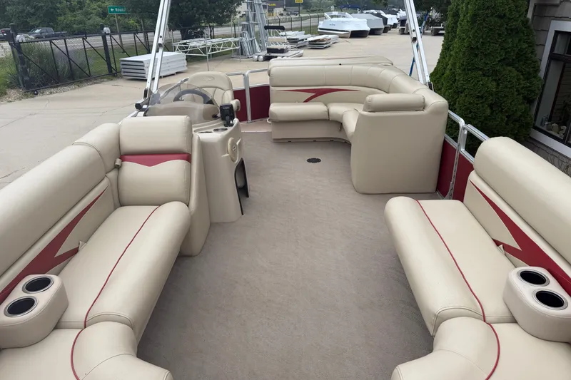 Slide: The Image of 2011 Harris Cruiser 220 pontoon boat with beige seating and red accents, docked outdoors. - 3