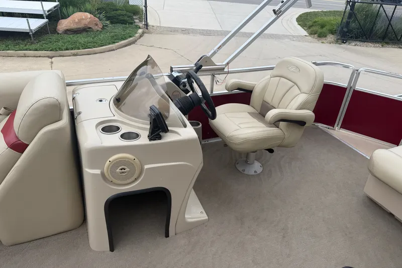 Slide: The Image of 2011 Harris Cruiser 220 boat interior with beige captain's chair and steering console. - 7