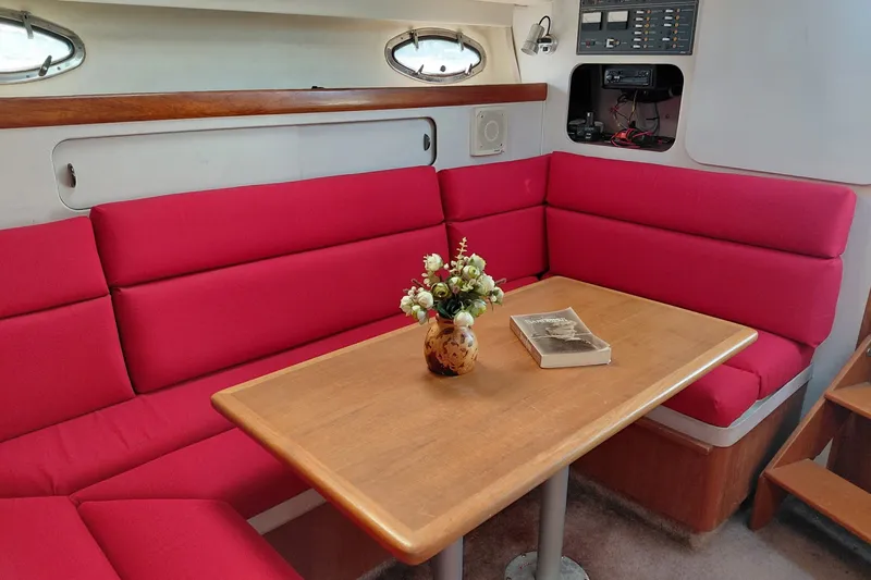 Slide: The Image of Interior of 1991 Tiara Yachts 3100 Open with red seating and wooden table. - 22