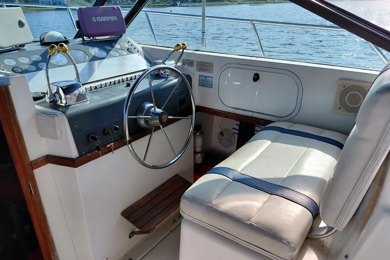 Slide: The Image of 1991 Tiara Yachts 3100 Open helm with steering wheel and Garmin navigation system. - 14