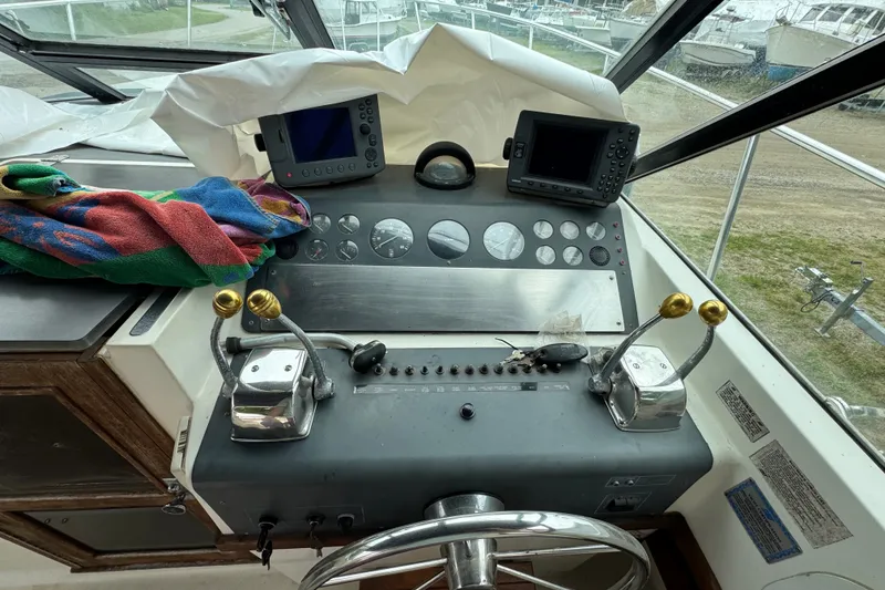 Slide: The Image of 1991 Tiara Yachts 3100 Open helm with dual controls and navigation screens. - 7