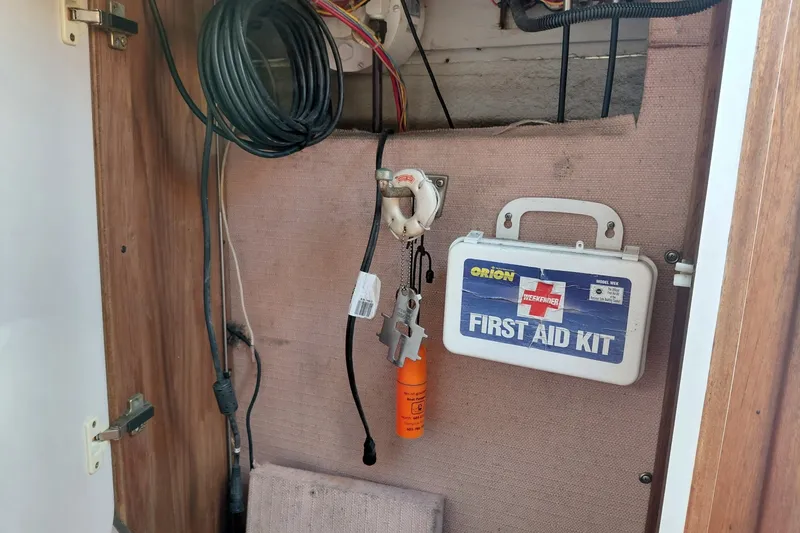 Slide: The Image of First aid kit and equipment inside a 1991 Tiara Yachts 3100 Open cabinet. - 28