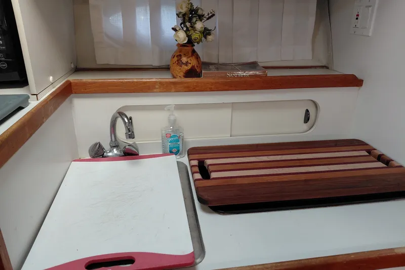 Slide: The Image of 1991 Tiara Yachts 3100 Open kitchen with sink, cutting boards, and decorative flowers. - 19