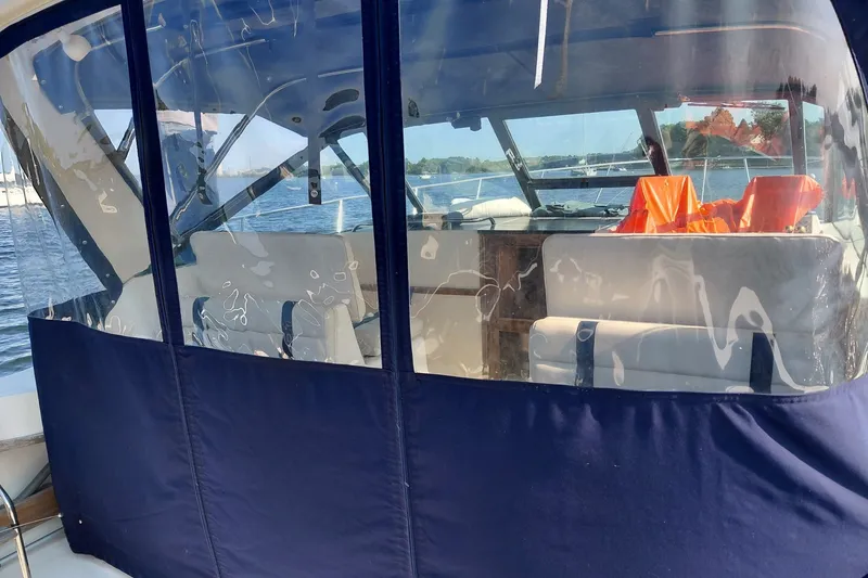 Slide: The Image of 1991 Tiara Yachts 3100 Open with enclosed cockpit, docked on a sunny day. - 11