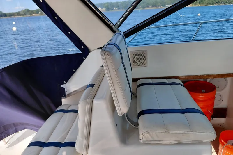 Slide: The Image of Interior of a 1991 Tiara Yachts 3100 Open, featuring cushioned seating and lake view. - 15