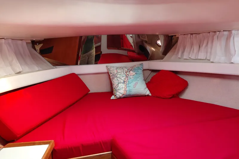 Slide: The Image of 1991 Tiara Yachts 3100 Open cabin with red bedding and decorative pillows. - 17