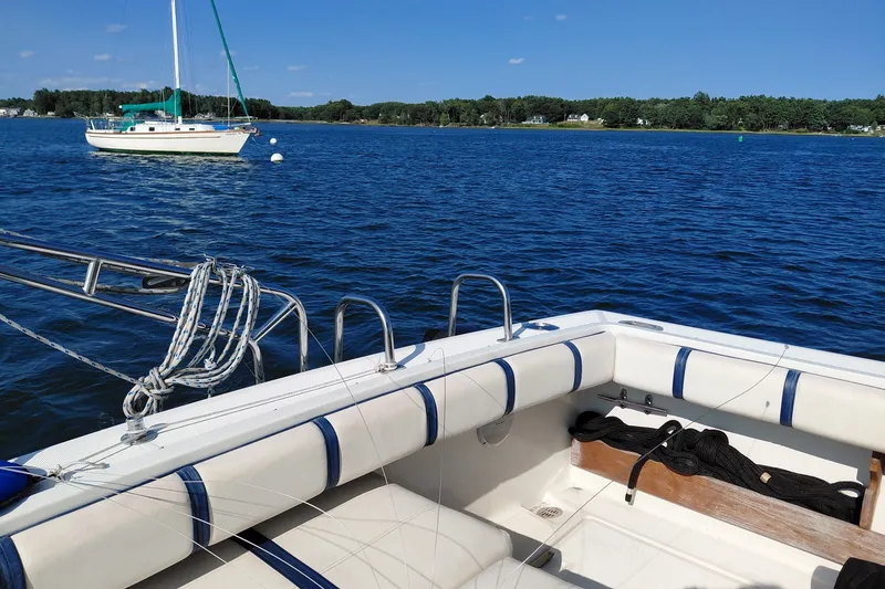 Slide: The Image of 1991 Tiara Yachts 3100 Open on serene blue water with sailboat in background. - 5