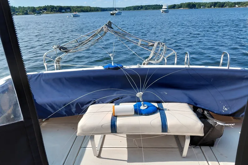 Slide: The Image of 1991 Tiara Yachts 3100 Open on water, featuring fishing gear and scenic lake view. - 2
