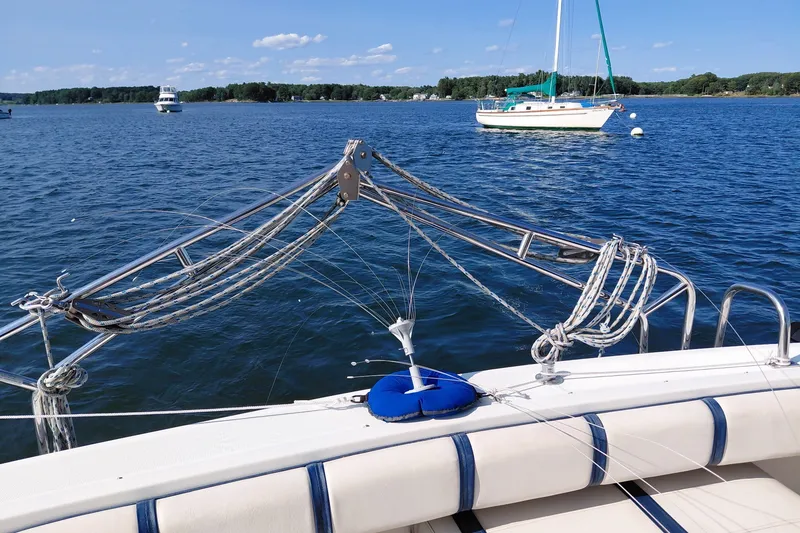 Slide: The Image of 1991 Tiara Yachts 3100 Open on serene lake with sailboats in background. - 12