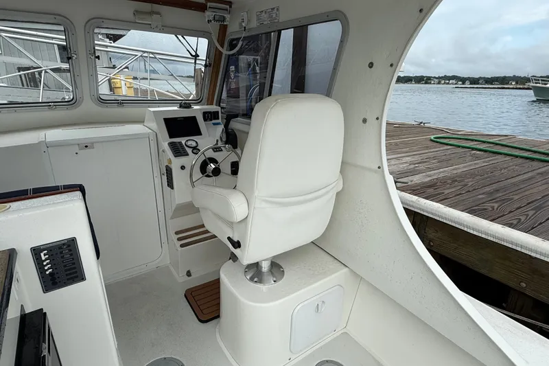 Slide: The Image of Interior of a 2020 Eastern 248 Islander boat with helm and white seating. - 7