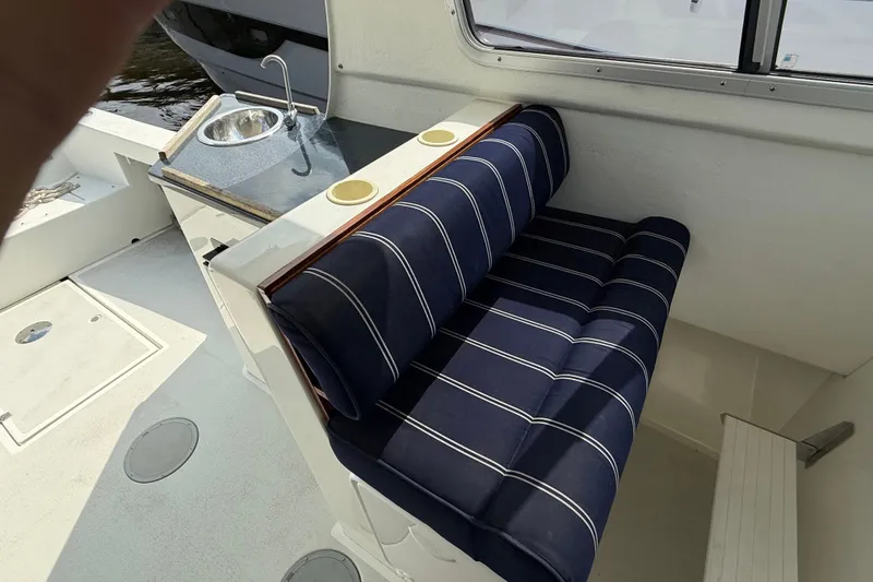 Slide: The Image of Interior of 2020 Eastern 248 Islander boat with striped seating and compact sink area. - 5